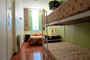 ポルトにあるDuas Nações Guest Houseのベッドルーム1室(二段ベッド2組付)、リビングルームが備わります。