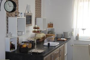 une cuisine avec un comptoir avec une horloge murale dans l'établissement Hotel und Restaurant Hohenzollern, à Erfurt 9 autres photos