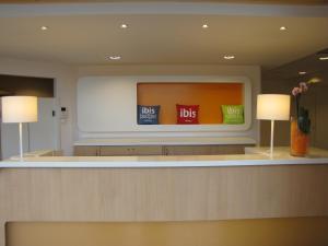uma televisão de ecrã plano num quarto com 2 candeeiros em ibis budget Hotel Brussels Airport em Diegem