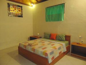 1 dormitorio con 1 cama, 2 mesas y una ventana en Santai Bungalow, en Gili Trawangan