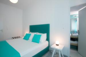 a bedroom with a bed with blue and white pillows at Acqua Vatos Paros Hotel in Parikia