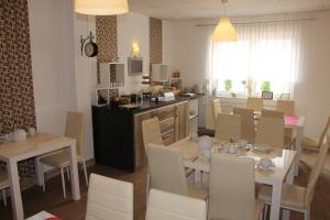 une cuisine et une salle à manger avec tables et chaises dans l'établissement Hotel und Restaurant Hohenzollern, à Erfurt