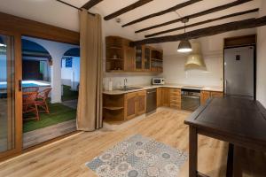 cocina grande con armarios de madera y mesa en Casa Rural Ensueño, en Casas del Cerro