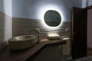 y baño con bañera y espejo redondo. en Casa Rural Ensueño, en Casas del Cerro