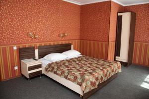 チタにあるChita Hotelのベッドルーム1室(大型ベッド1台、ナイトスタンド、ベッドサイドサイドサイドサイドサイドサイド付)