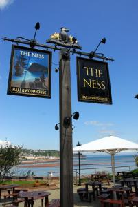 a pole with a sign for the nest and tables at The Ness in Teignmouth