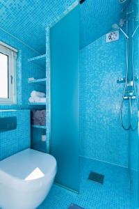 y baño azul con aseo y ducha. en Beach house in Oslo en Oslo
