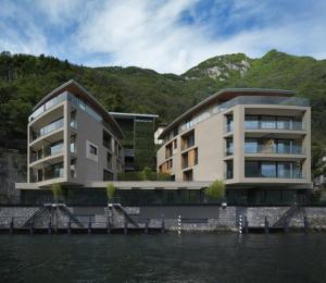 ラーリオにあるLaglio Como Lake Resortの水の隣の大きな建物