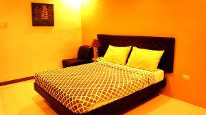 a bedroom with a bed with an orange wall at Urbantel Hotel in Lucena