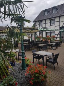un patio con mesas y sillas frente a un edificio en Hotel Restaurant Jägerhof, en Düren - Eifel