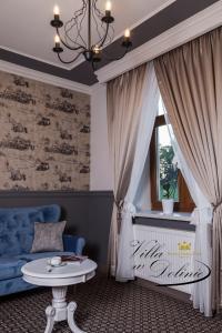 a living room with a blue couch and a window at Apartamenty Willa w Dolinie in Tarnów