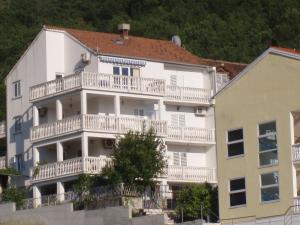 un edificio de apartamentos blanco con balcones y un árbol en Apartments Zvono, en Slano