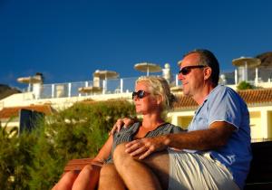 a man and a woman sitting on a bench at Hotel Gran Rey in Valle Gran Rey