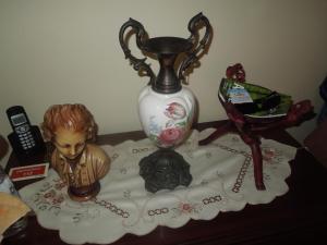 a vase sitting on a table with a doll on it at Borges Pimentel Apartment in Ponta Delgada