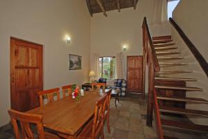 una sala da pranzo con tavolo in legno e scala di Hoopoe Haven Guest House a Chartwell