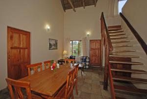 a dining room with a wooden table and a staircase at Hoopoe Haven Guest House in Chartwell
