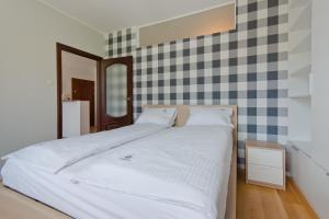 ソポトにあるImperial Apartments - Patio Mareのチェッカーボードの壁の白いベッドが備わるベッドルーム1室
