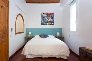 a bedroom with a white bed and a window at Casa Cosi Mallorca I in Barcelona