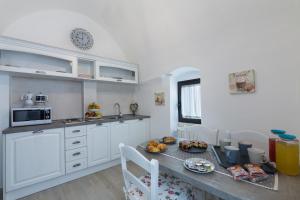 a kitchen with white cabinets and a table with food on it at B&B Mimmo e Valeria in Santeramo in Colle