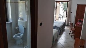 a bathroom with a toilet and a bed in a room at Hotel Roburent in Argentera