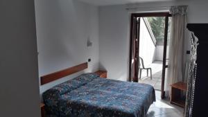 a bedroom with a bed and a door to a balcony at Hotel Roburent in Argentera
