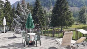 a patio with a table and chairs and trees at Hotel Roburent in Argentera
