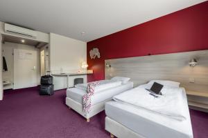 Кровать или кровати в номере Serways Hotel Heiligenroth