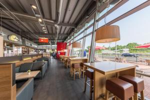 a restaurant with tables and chairs and windows at Serways Hotel Heiligenroth in Montabaur