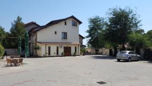 uma casa branca com um carro estacionado numa garagem em Pensiunea Romeo Tecuci em Tecuci