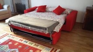 un letto rosso con due cuscini rossi sopra di Ca' Lina a Lainate