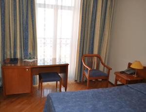1 dormitorio con escritorio, 1 cama y ventana en Ozerkovskaya Hotel, en Moscú