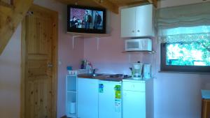 a kitchen with a white refrigerator and a tv on the wall at Jaani Puhkemaja in Pärnu