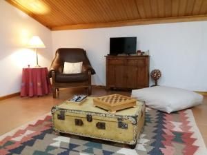 uma sala de estar com uma cadeira e uma mala em A casa da serra - alojamento local em Casal Velho