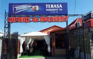 a sign for a restaurant with a tent and an umbrella at Casa Pozitiv Relax in Buzau