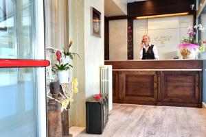 Een vrouw die met een mobieltje praat in een salon. bij Hotel La Sacca in Stresa