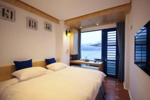 a bedroom with two beds and a large window at Sun Fog Hotel in Yuchi