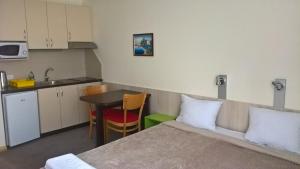 a room with a bed and a table and a kitchen at Apartments Mavesa in Vrnjačka Banja