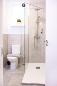 a bathroom with a toilet and a glass shower at Almijara Residence in Cómpeta +50 photos
