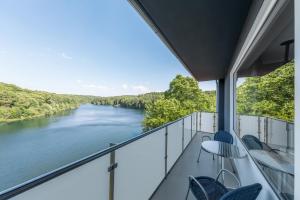 a balcony with chairs and a view of a river at Serways Hotel Remscheid in Remscheid