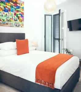 a bedroom with a bed with an orange blanket on it at Almijara Residence in Cómpeta