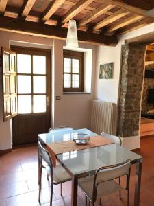 a dining room with a glass table and chairs at Agriturismo Il Pino in San Martino in Freddana