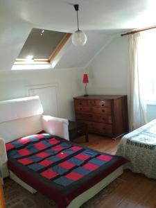 um quarto com uma cama, uma cómoda e uma janela em Morbey's Chalet em Sintra