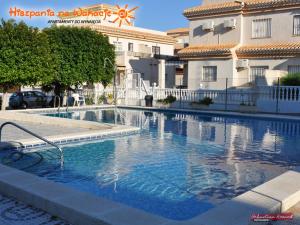 une piscine en face d'un bâtiment dans l'établissement Apartament Tina "Ozonizado", à Playa Flamenca