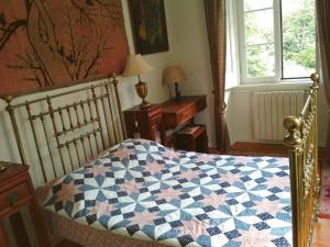 a bedroom with a bed with a quilt on it at Morbey's Chalet in Sintra