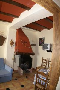 - un salon avec une cheminée et un canapé bleu dans l'établissement La Casa de la Abuela, à Cazorla