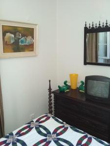 um quarto com uma cama e uma televisão numa cómoda em Morbey's Chalet em Sintra