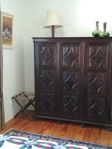 a wooden cabinet in a room with a lamp on top at Morbey's Chalet in Sintra