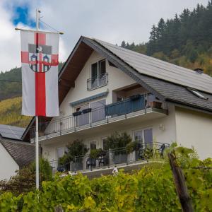 ein Gebäude mit einer Flagge davor in der Unterkunft Gästehaus FALKLAY in Burg (an der Mosel)