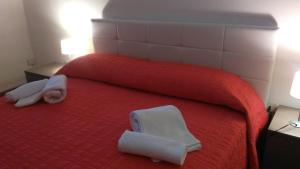サッサリにあるBed & Breakfast La Landriggaのベッドルーム1室(赤いベッド1台、タオル2枚付)