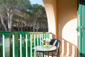 a table on a balcony with a vase of flowers at Hotel Dei Pini in Alghero